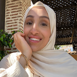 Safaa smiles for the camera, wearing a cream coloured hijab.