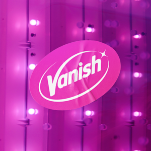 A still from the campaign film of the pink lighting of a sensory room. The pink Vanish logo sits over the image.